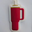 A red insulated tumbler mug with a white handle and lid, shown from a top-down view on a white sheet of paper.